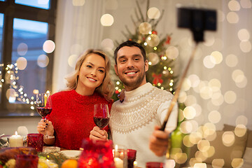 Image showing couple taking picture by selfie stick at christmas