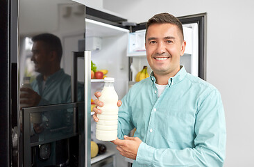 Image showing man taking milk from fridge at home kitchen