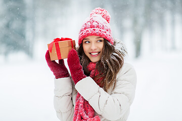 Image showing happy young woman with christmas gift in winter