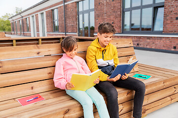 Image showing school children reading books sitting on bench