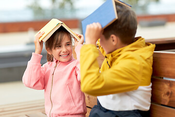 Image showing school children with books having fun outdoors