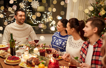 Image showing happy friends having christmas dinner at home