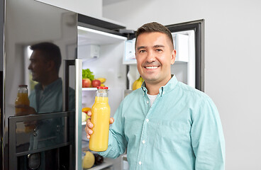 Image showing man taking juice from fridge at home kitchen