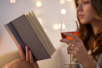 Image showing close up of woman reading book and drinking wine