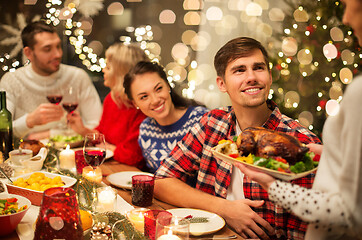 Image showing happy friends having christmas dinner at home