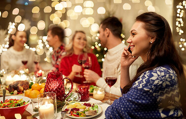 Image showing woman calling on smartphone at christmas dinner