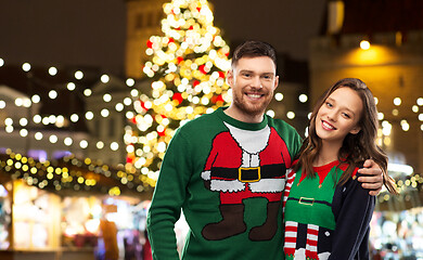 Image showing happy couple in ugly sweaters at christmas market