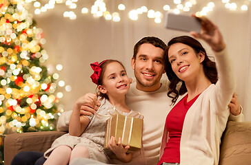 Image showing happy family with christmas present at home