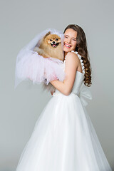 Image showing beautiful bride girl with spitz bride on gray background