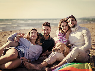 Image showing Group of friends having fun on beach during autumn day