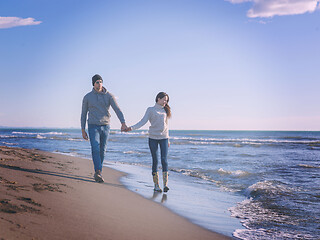 Image showing Loving young couple on a beach at autumn sunny day