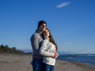 Image showing Loving young couple on a beach at autumn sunny day