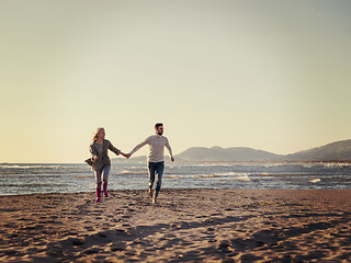 Image showing Loving young couple on a beach at autumn sunny day