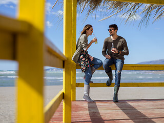 Image showing young couple drinking beer together at the beach