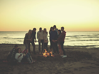 Image showing Couple enjoying bonfire with friends on beach