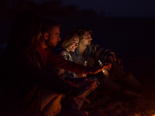 Image showing Couple enjoying with friends at night on the beach