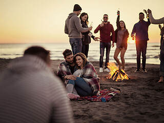 Image showing Couple enjoying with friends at sunset on the beach