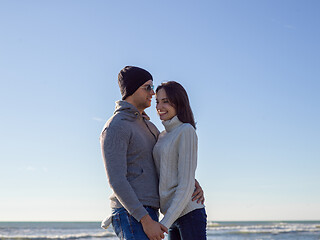 Image showing Loving young couple on a beach at autumn sunny day