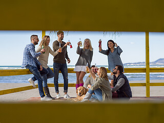 Image showing Group of friends having fun on autumn day at beach