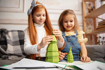 Image showing Two little children, girls together in creativity of the house. Happy kids make handmade toys for games or New Year celebration