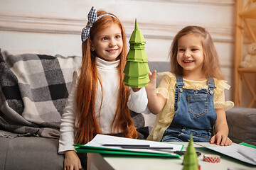 Image showing Two little children, girls together in creativity of the house. Happy kids make handmade toys for games or New Year celebration