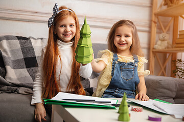 Image showing Two little children, girls together in creativity of the house. Happy kids make handmade toys for games or New Year celebration