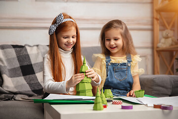 Image showing Two little children, girls together in creativity of the house. Happy kids make handmade toys for games or New Year celebration