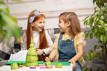 Image showing Two little children, girls together in creativity of the house. Happy kids make handmade toys for games or New Year celebration