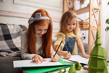 Image showing Two little children, girls together in creativity of the house. Happy kids make handmade toys for games or New Year celebration