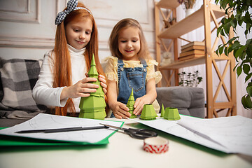 Image showing Two little children, girls together in creativity of the house. Happy kids make handmade toys for games or New Year celebration