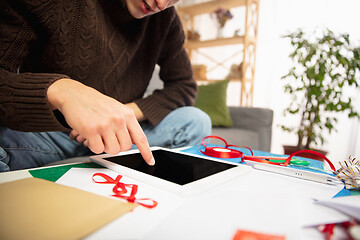 Image showing Man reading message, greetings for New Year and Christmas 2021 from friends or family with his tablet