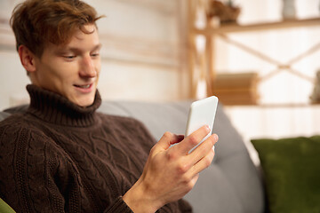 Image showing Man reading message, greetings for New Year and Christmas 2021 from friends or family with his cellphone