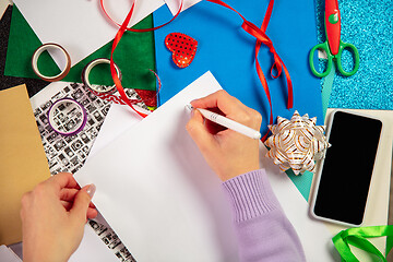 Image showing Woman making greeting card for New Year and Christmas 2021 for friends or family, scrap booking, DIY