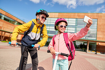 Image showing happy school kids with scooters taking selfie