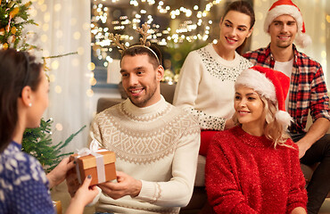 Image showing friends celebrating christmas and giving presents
