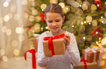 Image showing smiling girl with christmas gift at home