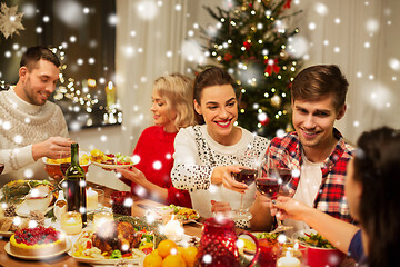 Image showing happy friends drinking red wine at christmas party