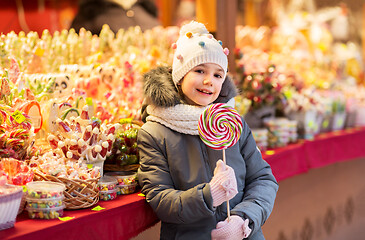 Image showing girl with lollipop at christmas market candy shop