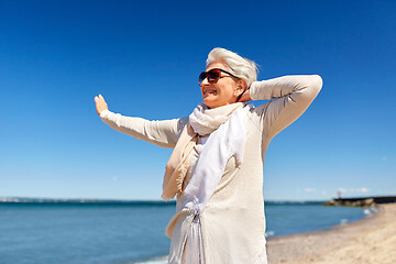 Image showing portrait of senior woman in sunglasses on beach