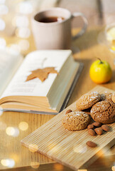 Image showing oat cookies, almonds and book on table at home