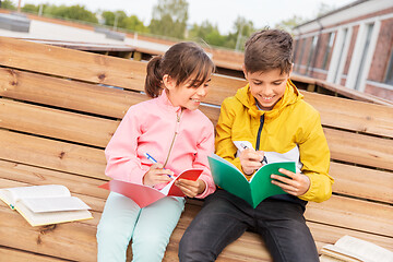 Image showing school children with notebooks sitting on bench