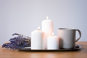Image showing candles, tea in mug and lavender flowers on table