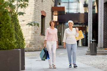 Image showing senior women with shopping bags walking in city