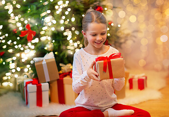 Image showing smiling girl with christmas gift at home