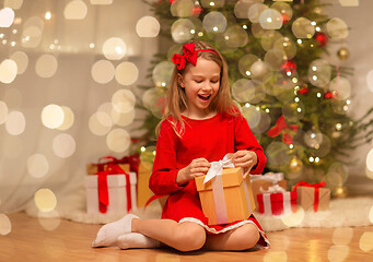 Image showing smiling girl with christmas gift at home