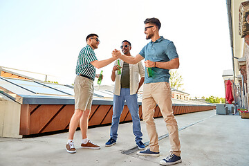 Image showing happy male friends with beer meeting on rooftop