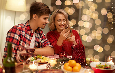 Image showing couple with smartphone at home christmas dinner