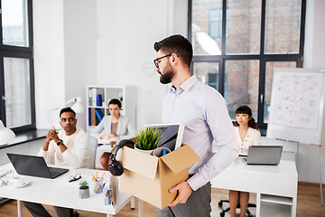 Image showing sad fired male office worker with personal stuff