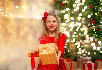 Image showing smiling girl with christmas gift at home