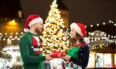 Image showing happy couple with gift at christmas market